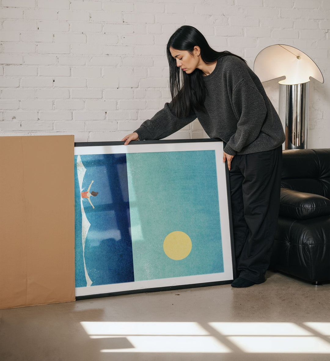 Woman holding an abstract artwork in a living room.