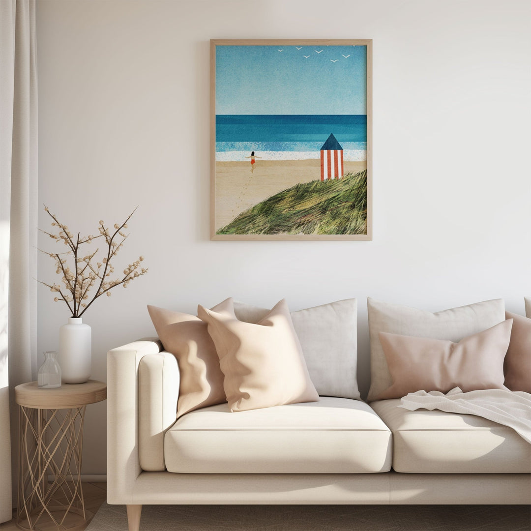 Living room with a beige sofa, decorative pillows, and a beach scene on the wall.