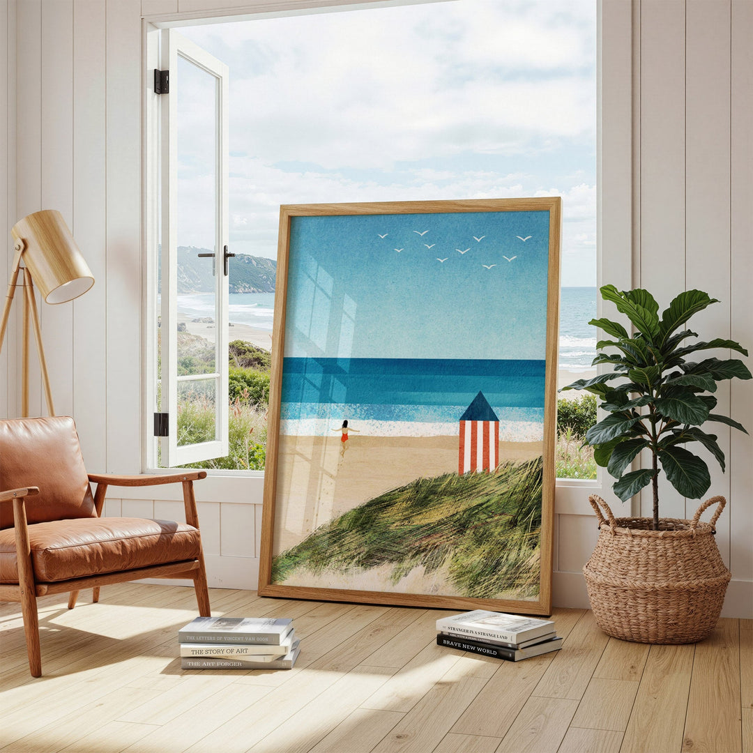 Beach scene artwork in a room with a chair, plant, and window.