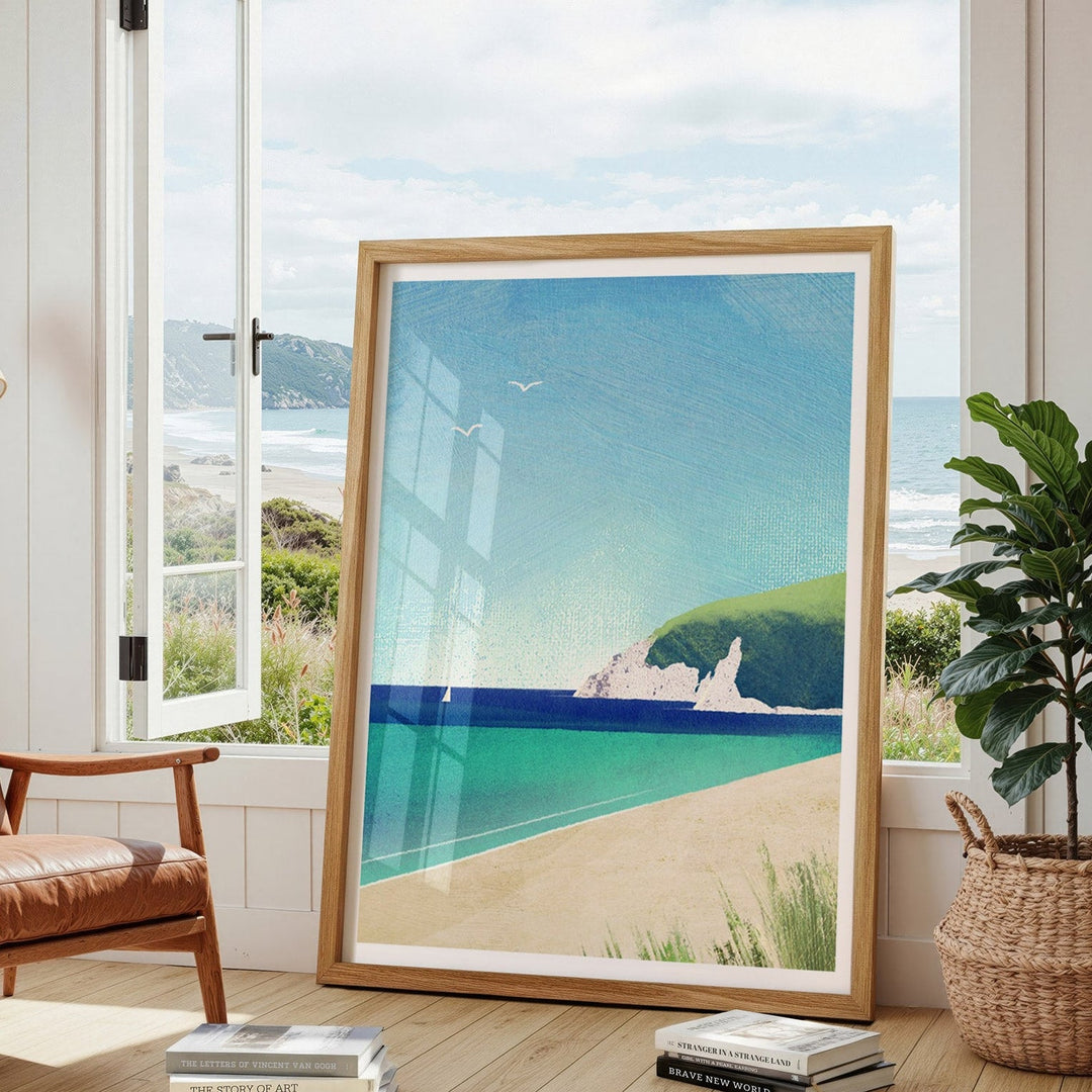 Beach scene print in a modern living room with a leather chair and plant.