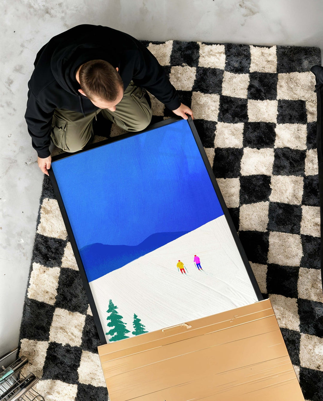 Person unboxing artwork on a checkered floor