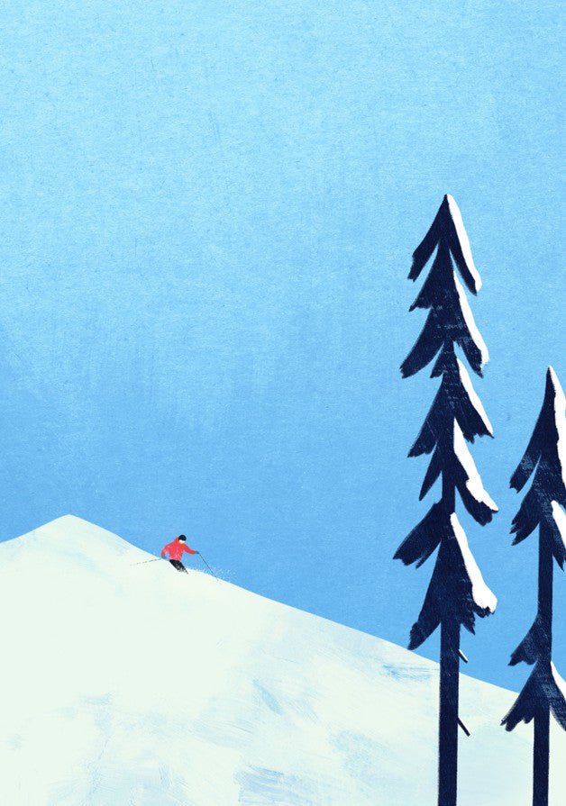 Skiier on a snowy mountain with two trees against a blue sky. framed