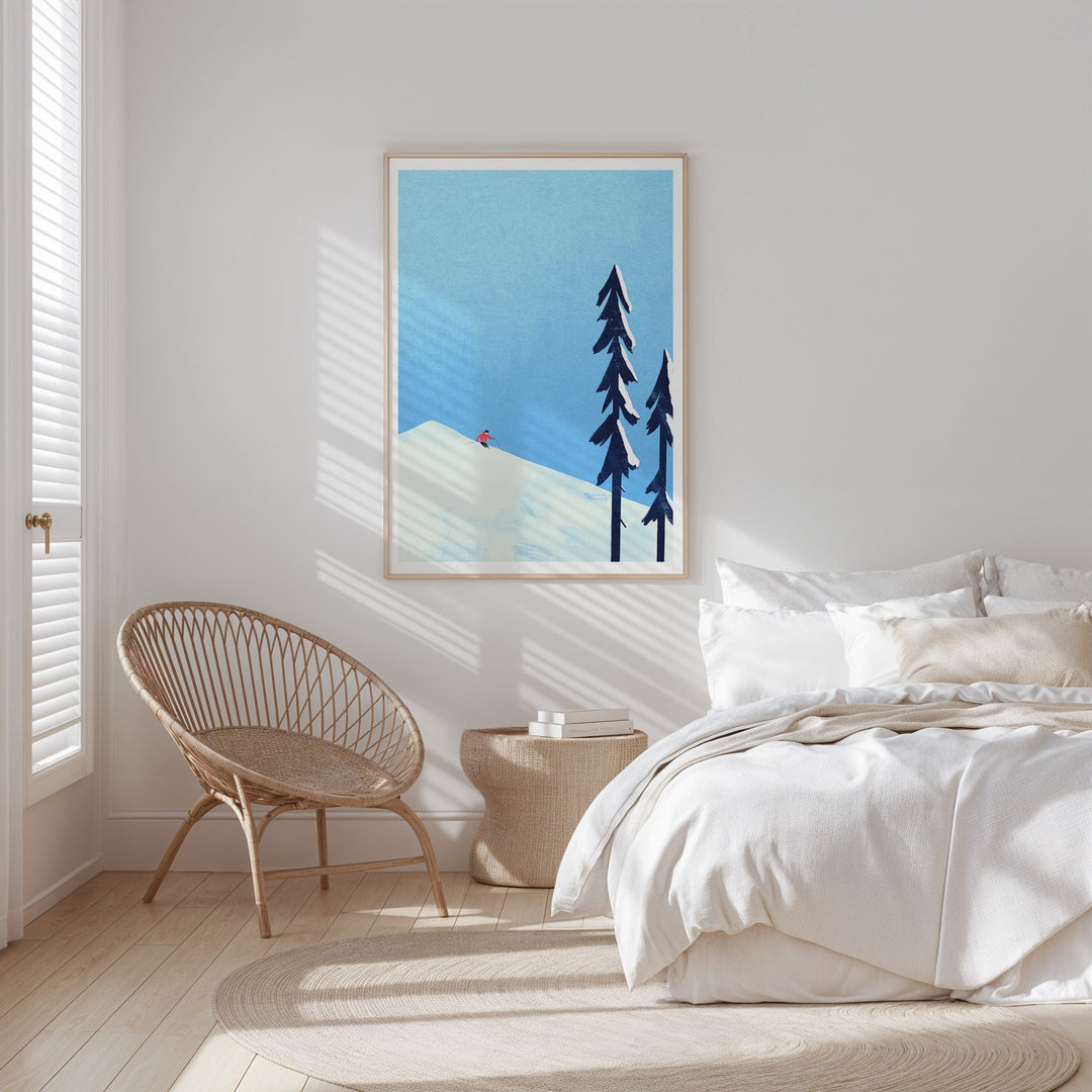 Modern bedroom with a bed, chair, and wall art of trees and mountains.