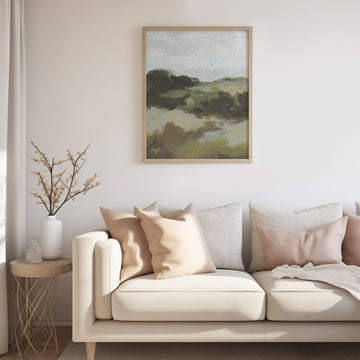Living room with a beige sofa, decorative pillows, and a landscape painting on the wall.