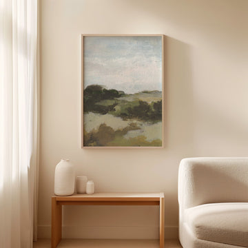 landscape painting on a wall above a wooden side table with decorative vases, next to a beige sofa.