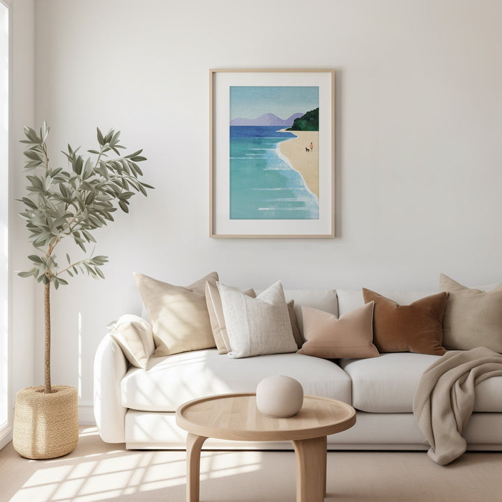 Living room with a white sofa, wooden coffee table, and beach-themed artwork on the wall.