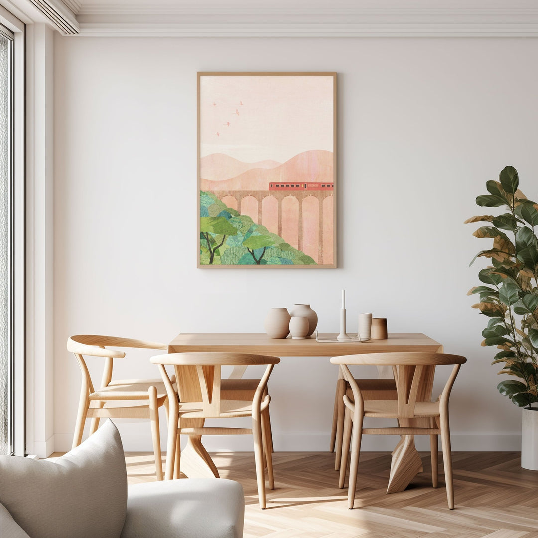Dining room with wooden table and chairs, artwork on the wall, and a plant.