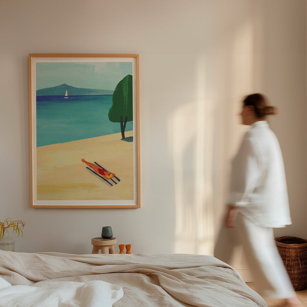 Woman walking past a painting of a beach scene in a room with neutral decor.