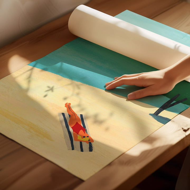 Hand rolling out a colorful mat with a design of a person on a beach.