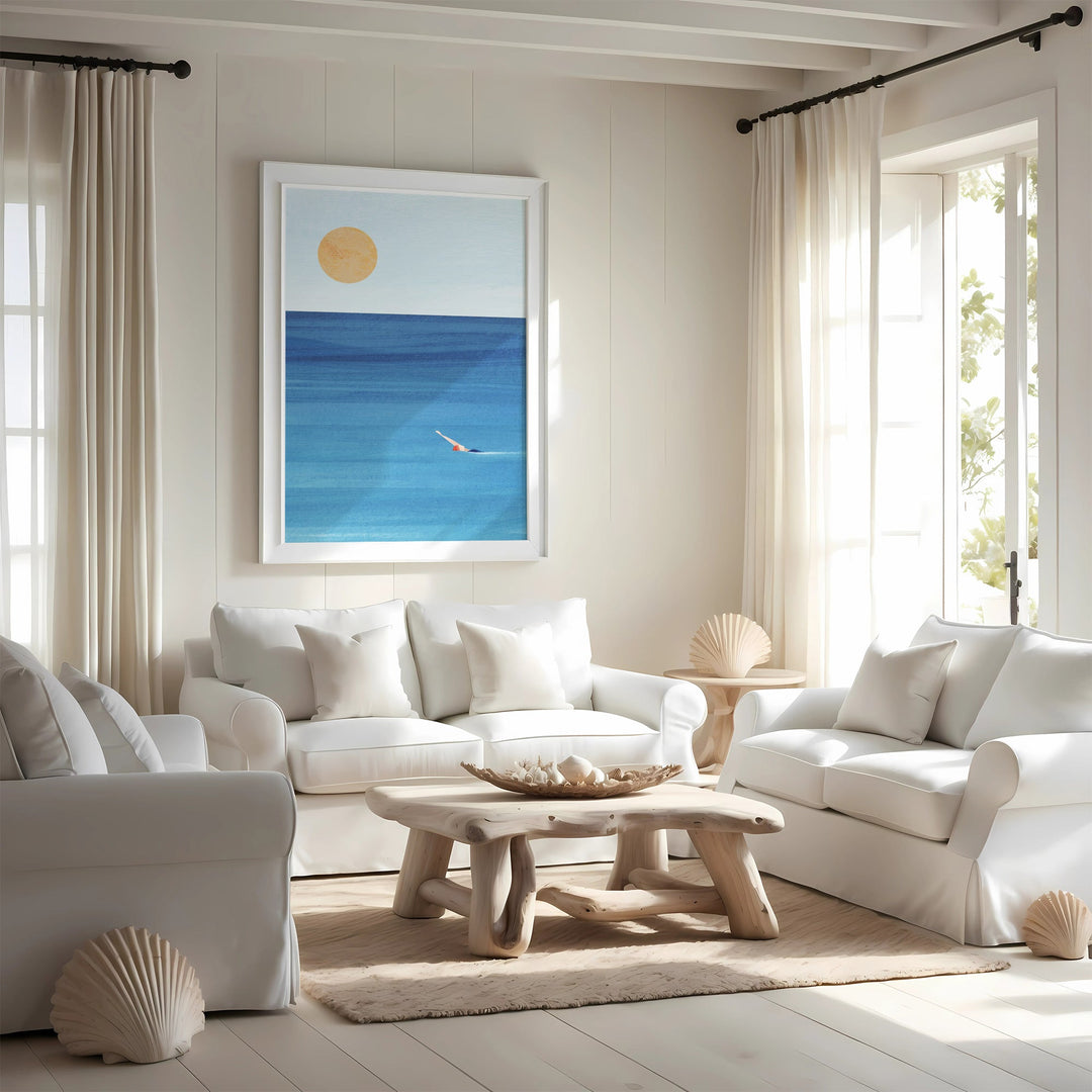 Modern living room with white furniture, a wooden coffee table, and a beach-themed wall art.