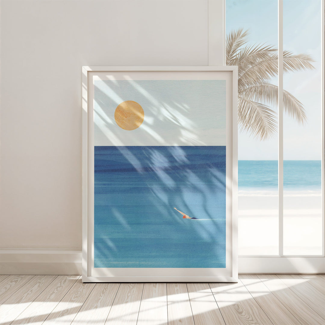 Artwork of a beach scene with palm tree and sun, displayed in a room with wooden floor and white walls.