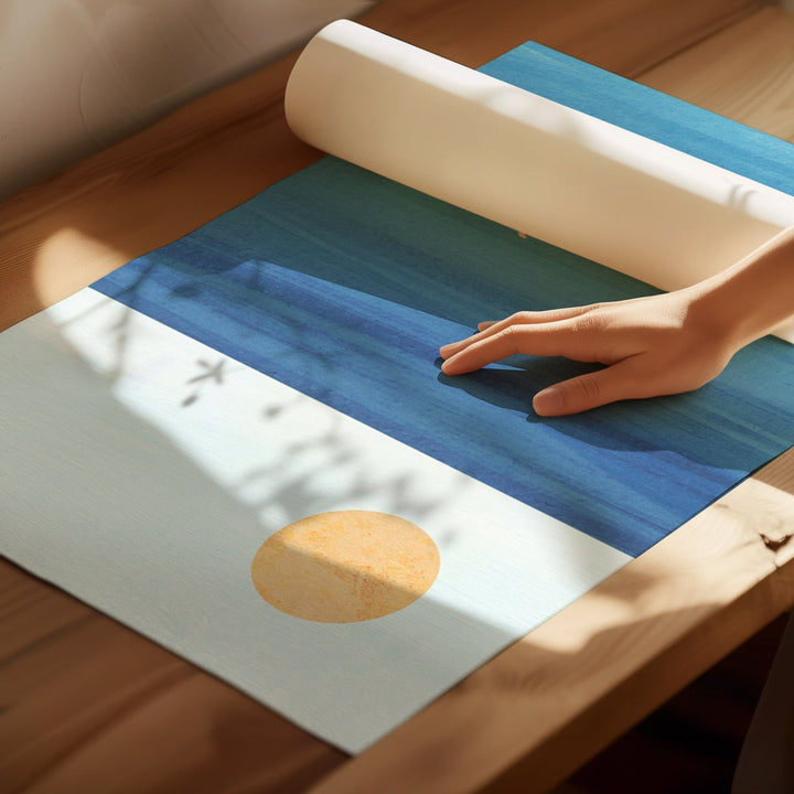 Person rolling out a blue and white mat on a wooden floor