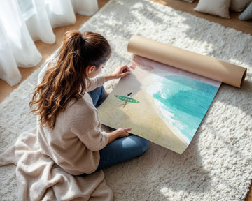 Woman unrolling a large piece of paper with a scenic design on a carpeted floor.