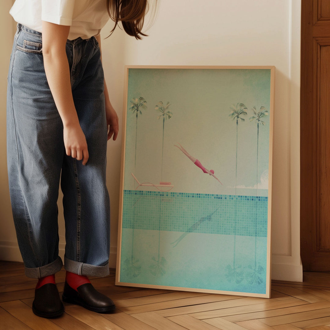 Person standing next to an artwork of a pool scene with palm trees.