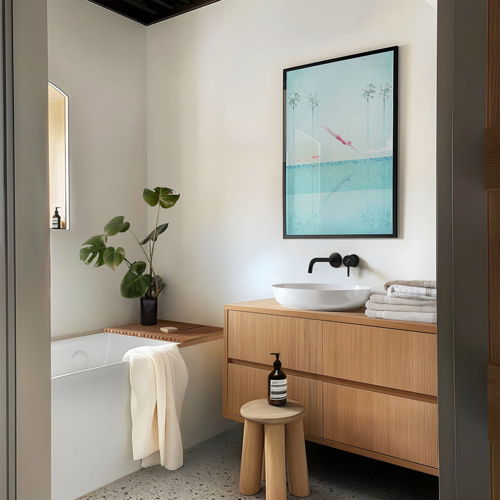 Modern bathroom with wooden vanity, bathtub, and artwork on the wall.