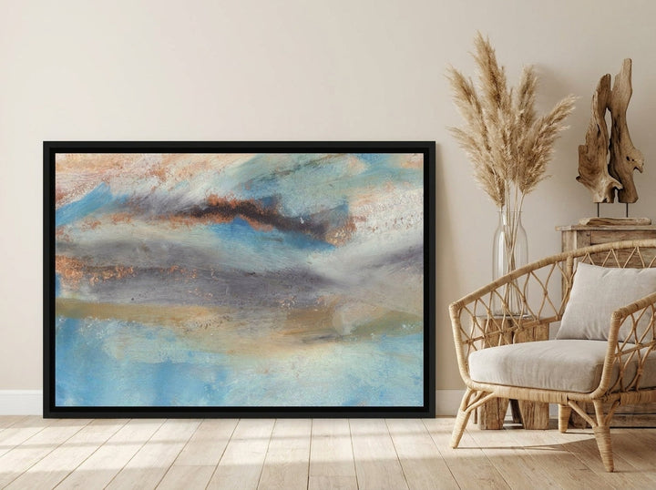 Oversized statement canvas wall art with a black surround leaning against the wall in a coastal dining room
