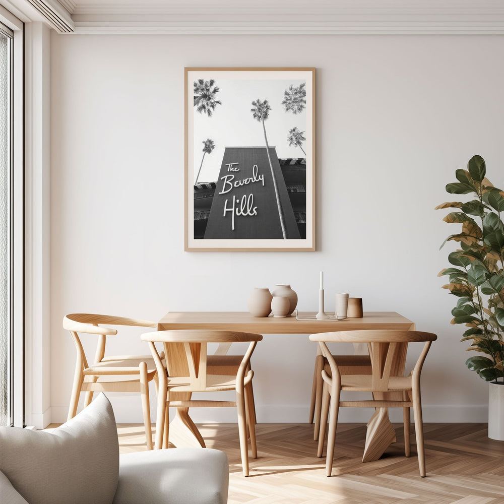 Dining room with wooden table and chairs, artwork on the wall, and a plant.