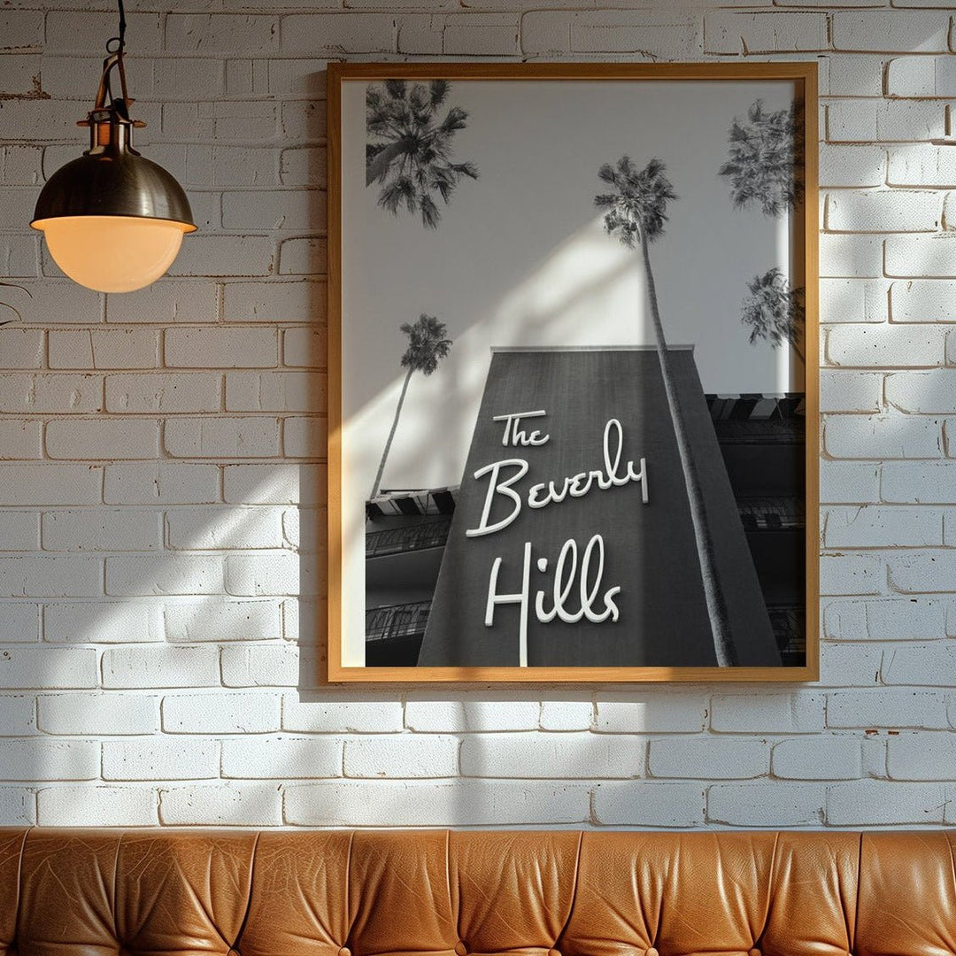 poster of The Beverly Hills hotel on a brick wall above a brown leather booth.