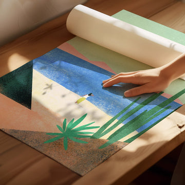 Hand rolling out a colorful beach scene mat on a wooden floor