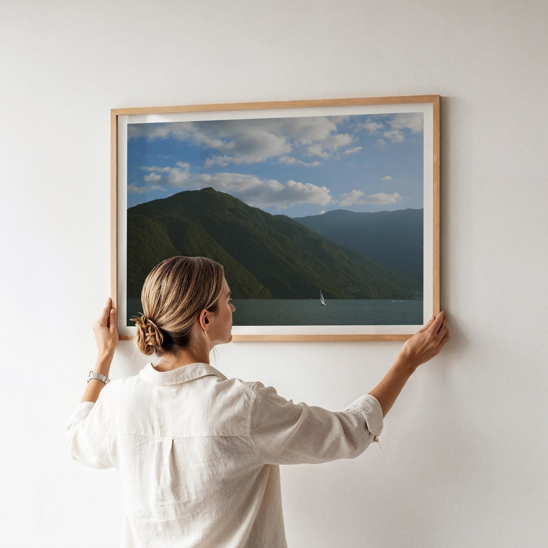 girl hanging a photo on white wall