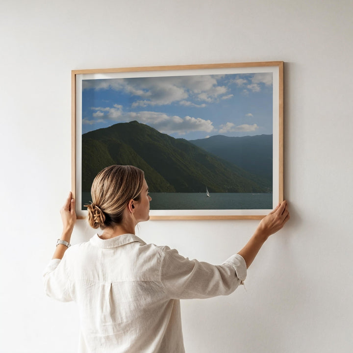 girl hanging a photo on white wall