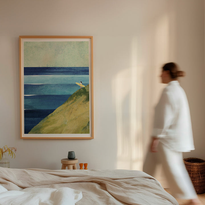 Woman walking past a landscape painting in a room with neutral decor.