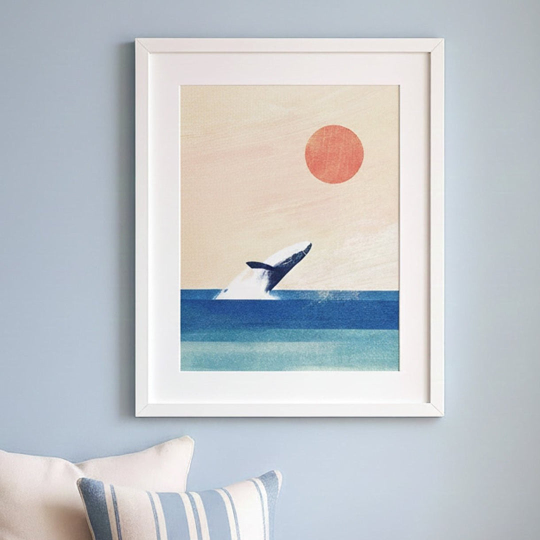 Wooden bench with pillows and a hat against a wall with artwork of a whale and sun.