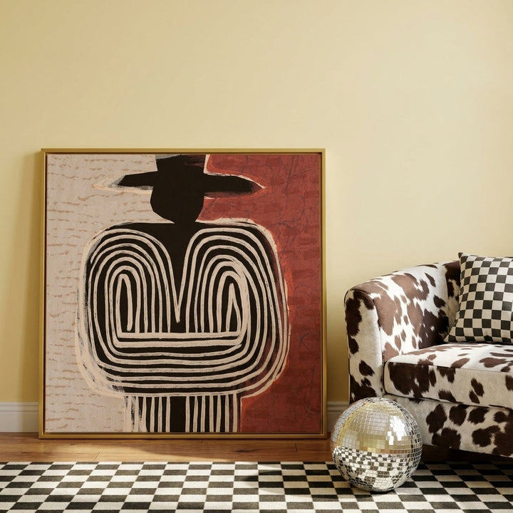Canvas wall art with a gold leaf surround leaning against the wall in a colourful eclectic bedroom