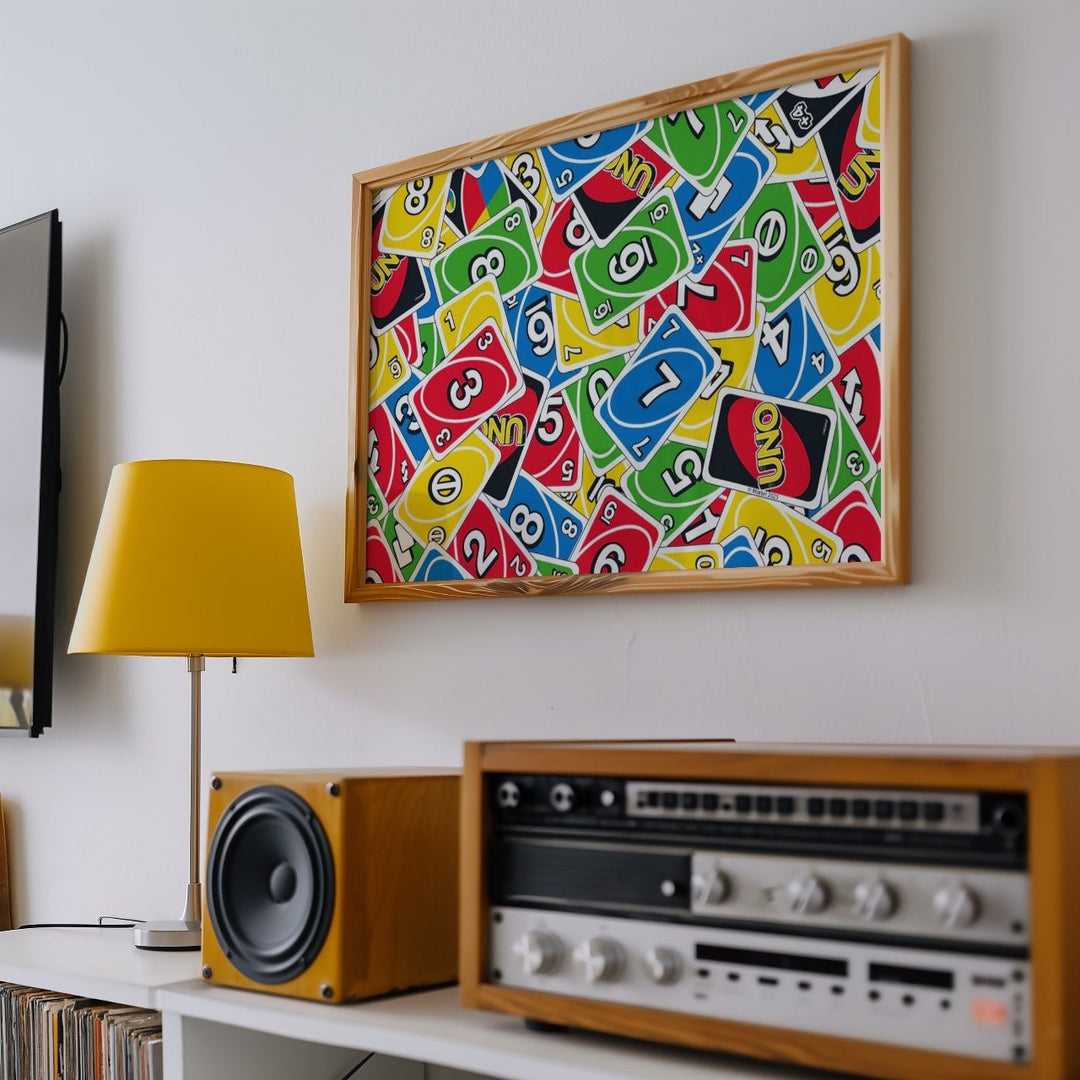 Colorful abstract art piece above a vintage radio and speaker in a room.
