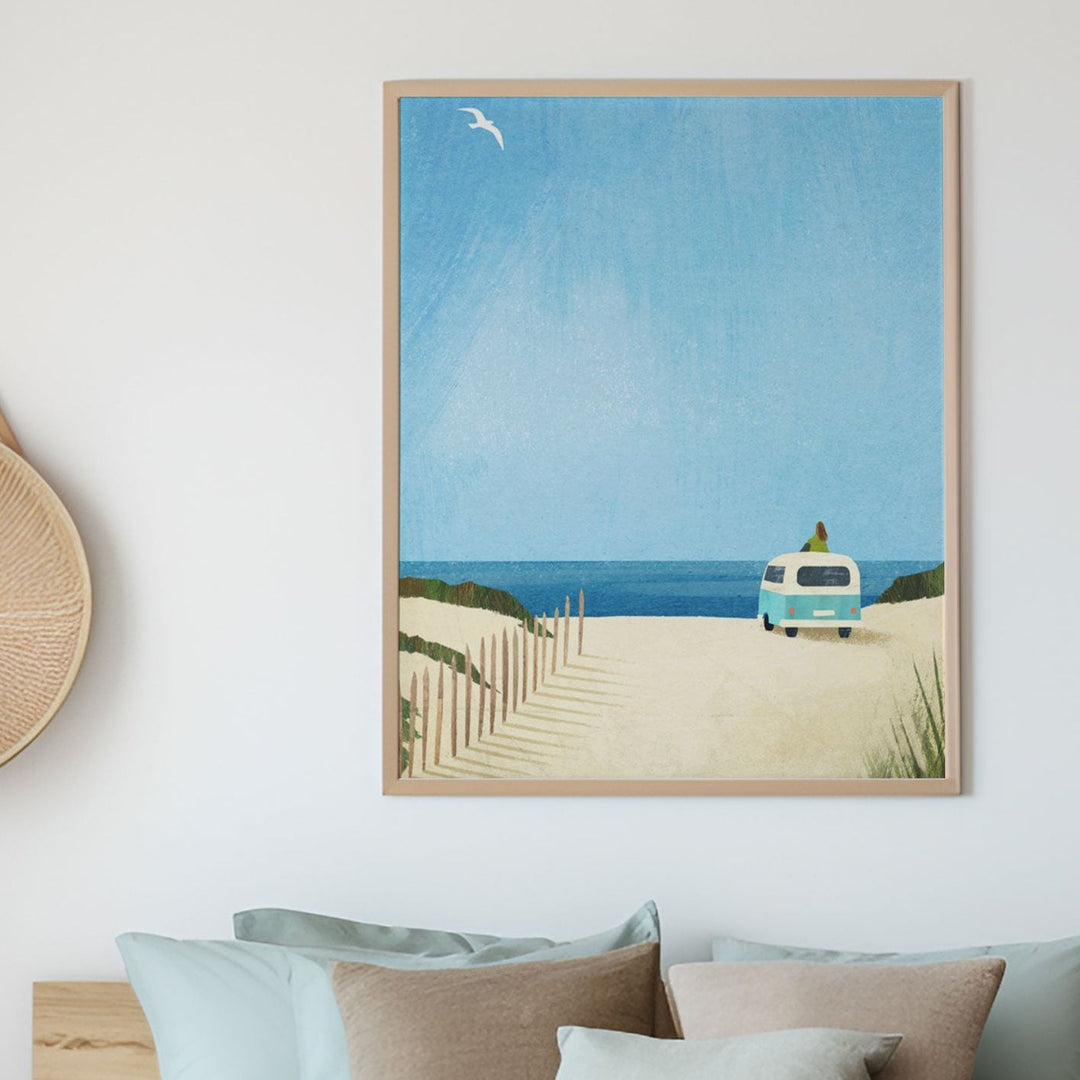 Modern bedroom with a bed, decorative pillows, and beach scene on the wall.