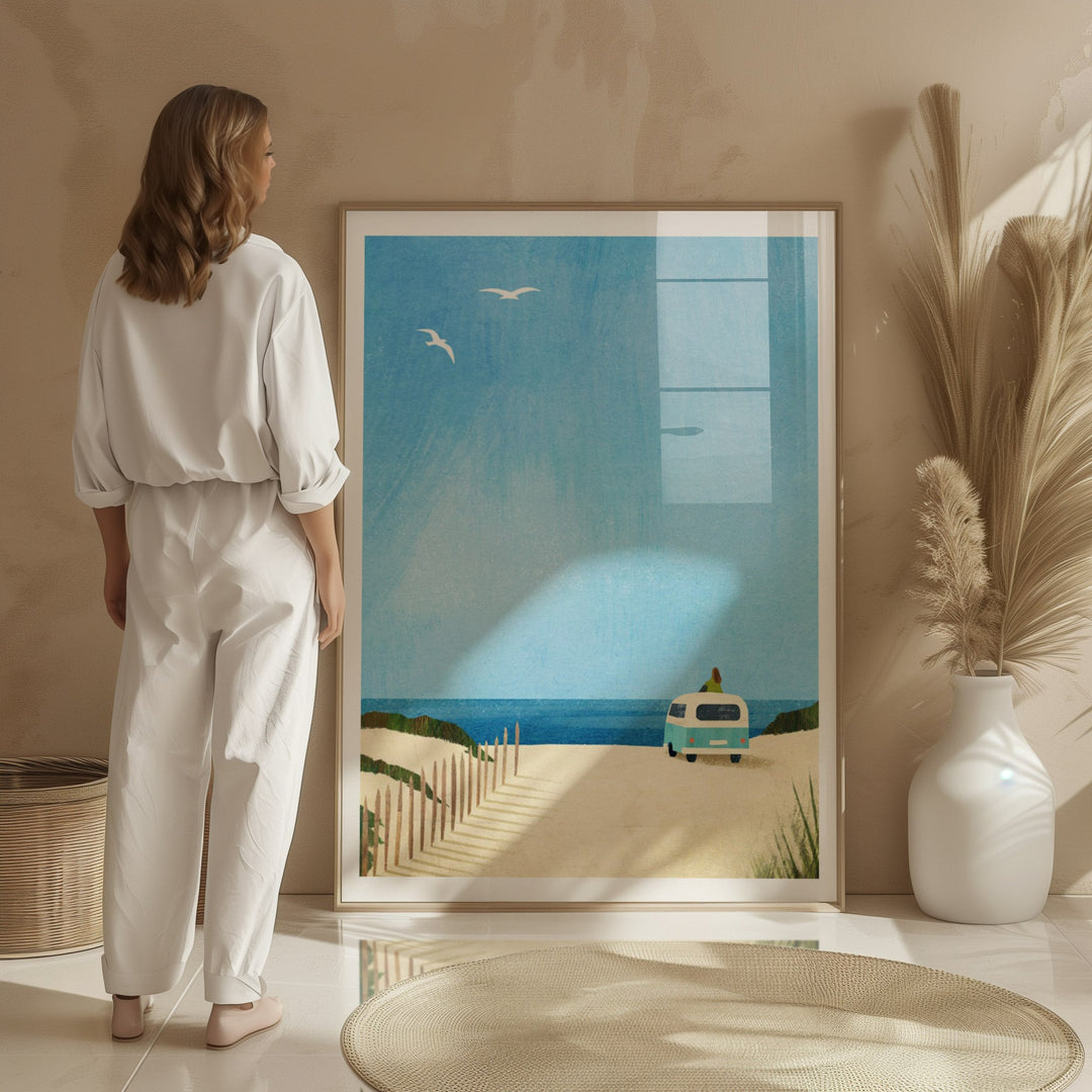 Woman in a white outfit standing next to artwork of a beach scene with a van.