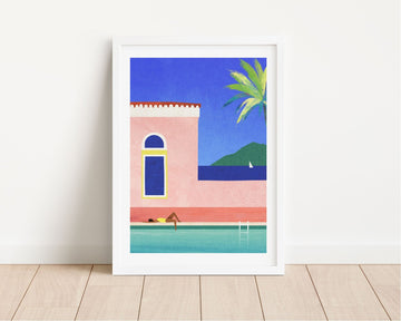Artwork of a pink building with a pool and palm tree on a white wall.