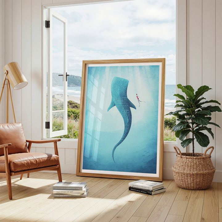 Artwork of a whale and fish in an ocean scene, placed in a room with a window view of a beach.