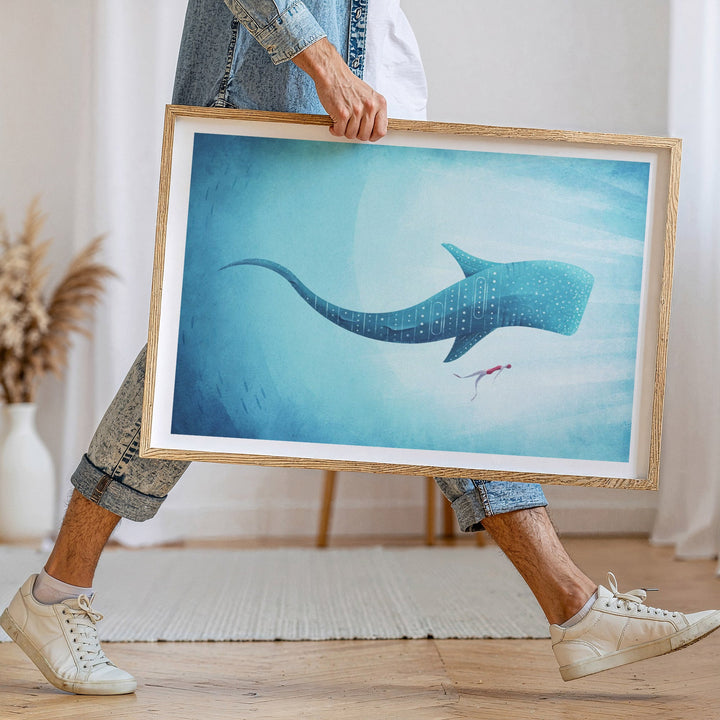 Person holding artwork of a whale underwater scene