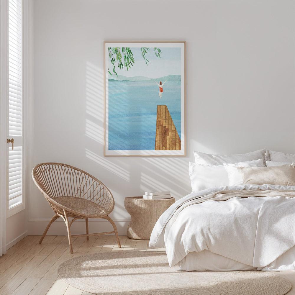 Bedroom with a bed, chair, and wall art of a person on a dock.